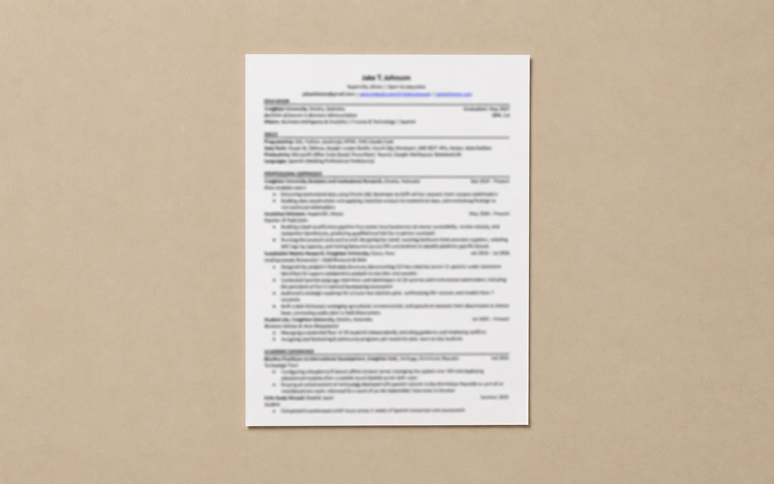 A printed résumé page on a warm neutral surface, its text too soft to read.